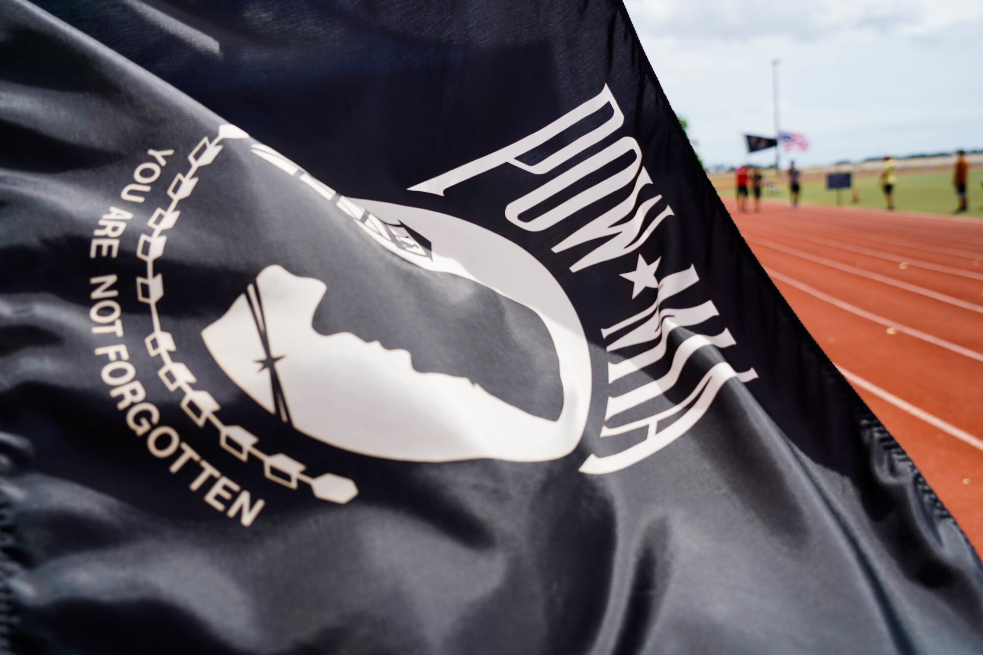 The Prisoner of War and Missing in Action flag waves during a 24-hour run at Joint Base Pearl Harbor-Hickam, Hawaii, Sept. 16, 2021. The POW/MIA flag displays a silhouette of a prisoner of war, displaying the determination to account for all service members unaccounted for. (U.S. Air Force photo by Airman 1st Class Makensie Cooper)