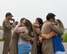 spouses hug their loved ones as they return from deployment