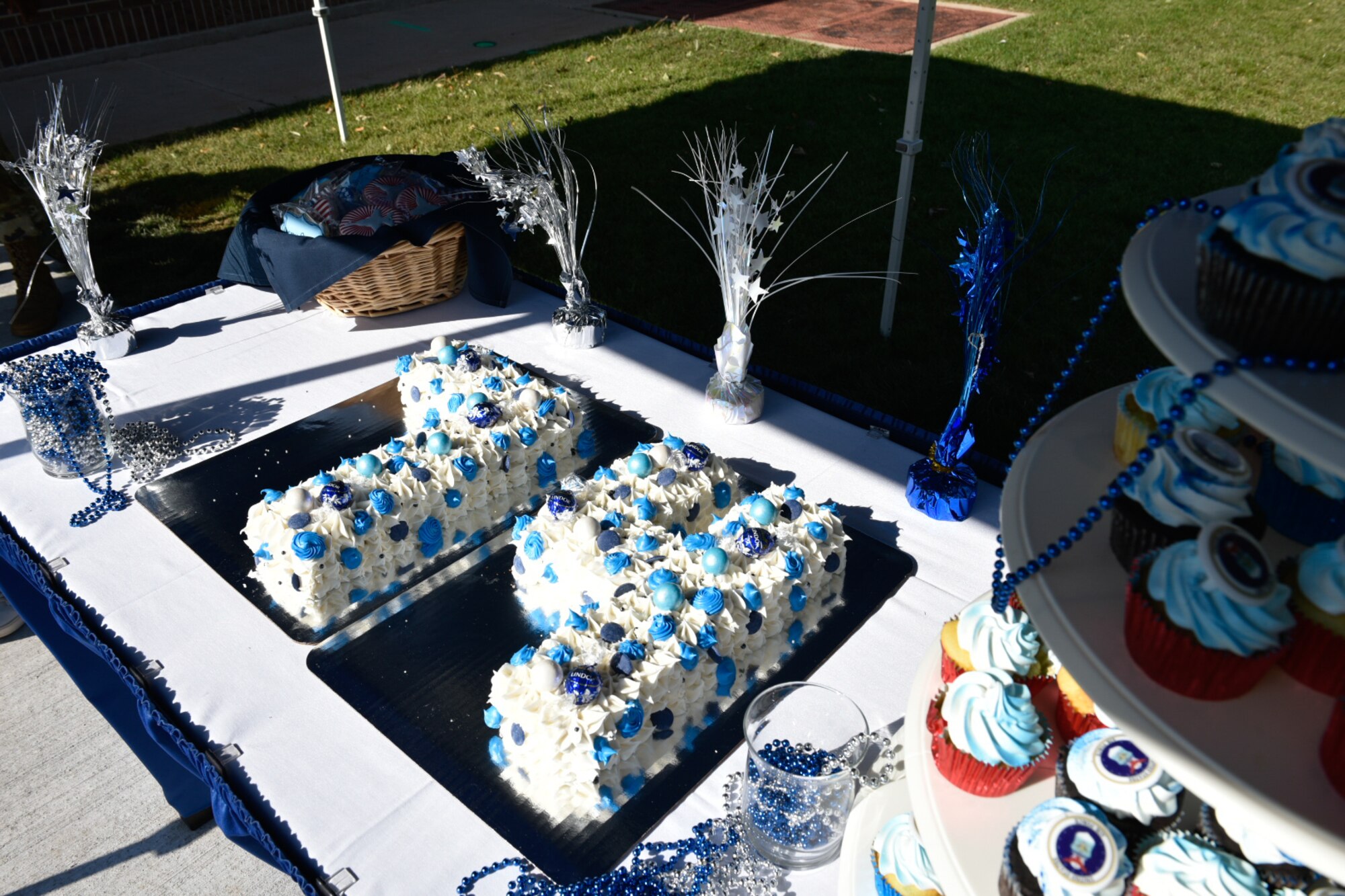 Air force birthday cake in the shape of the number 74 with white frosting and blue sprinkles