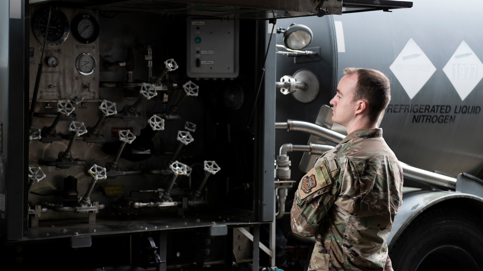An Airman looks over the many gas valve controls of a nitrogen gas truck