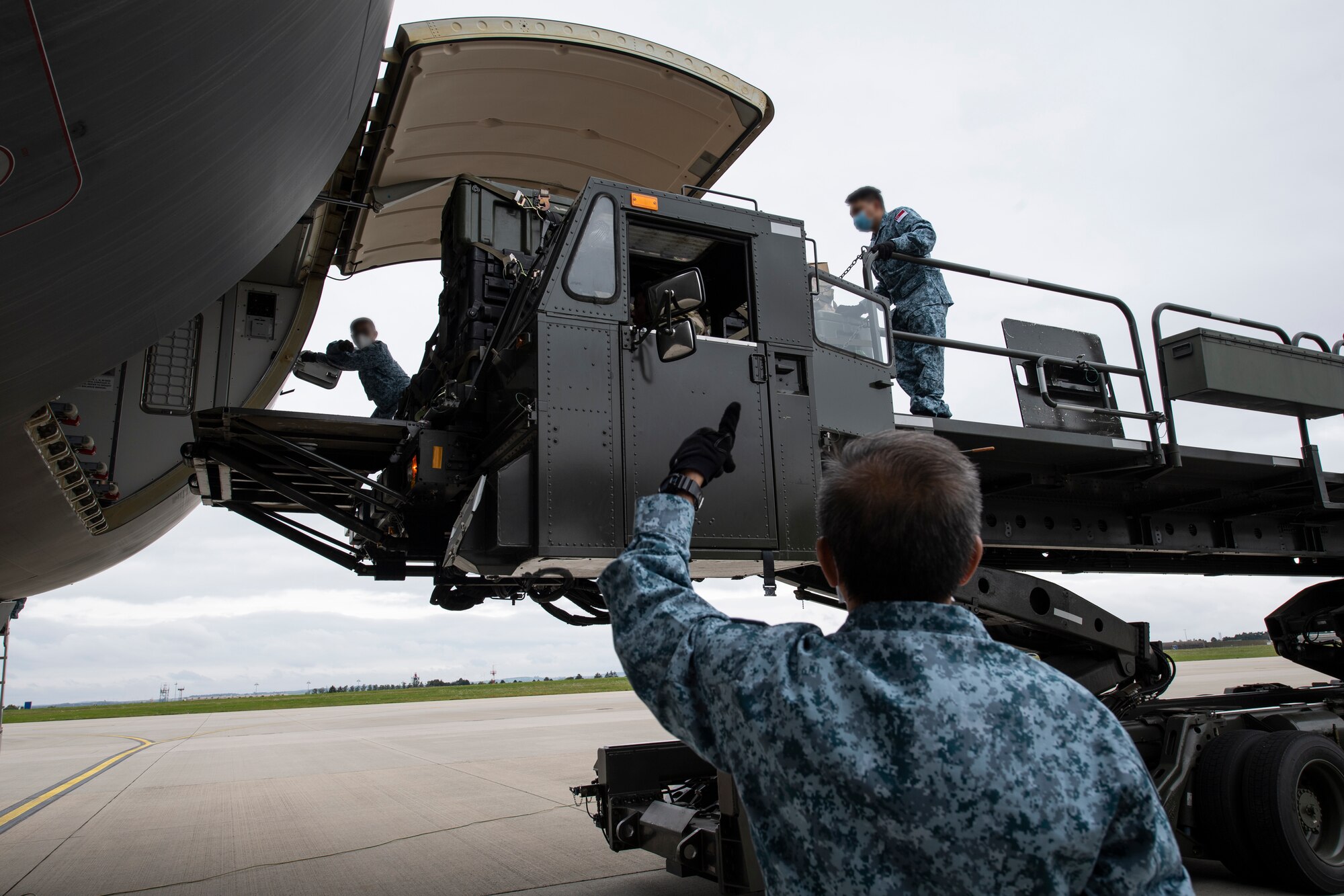 Republic of Singapore Air Force work with a U.S. Air Force Airman to load cargo onto a RSAF A330 Multi-Role Tanker Transport aircraft.