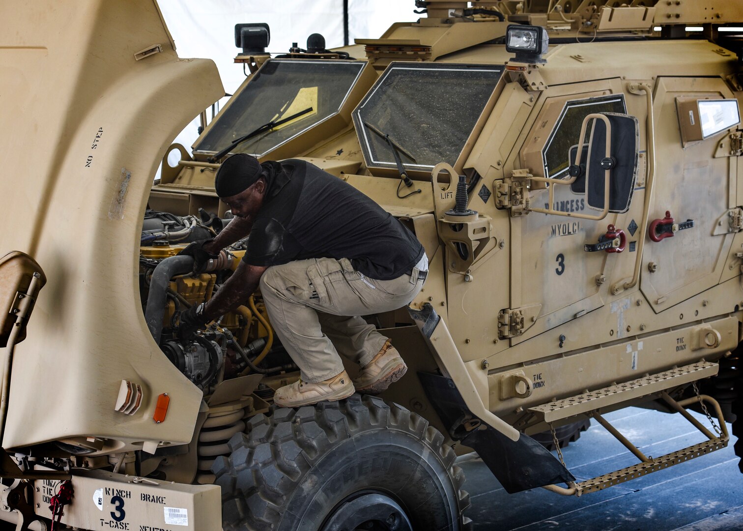 A photo of a man inspecting a vehicle