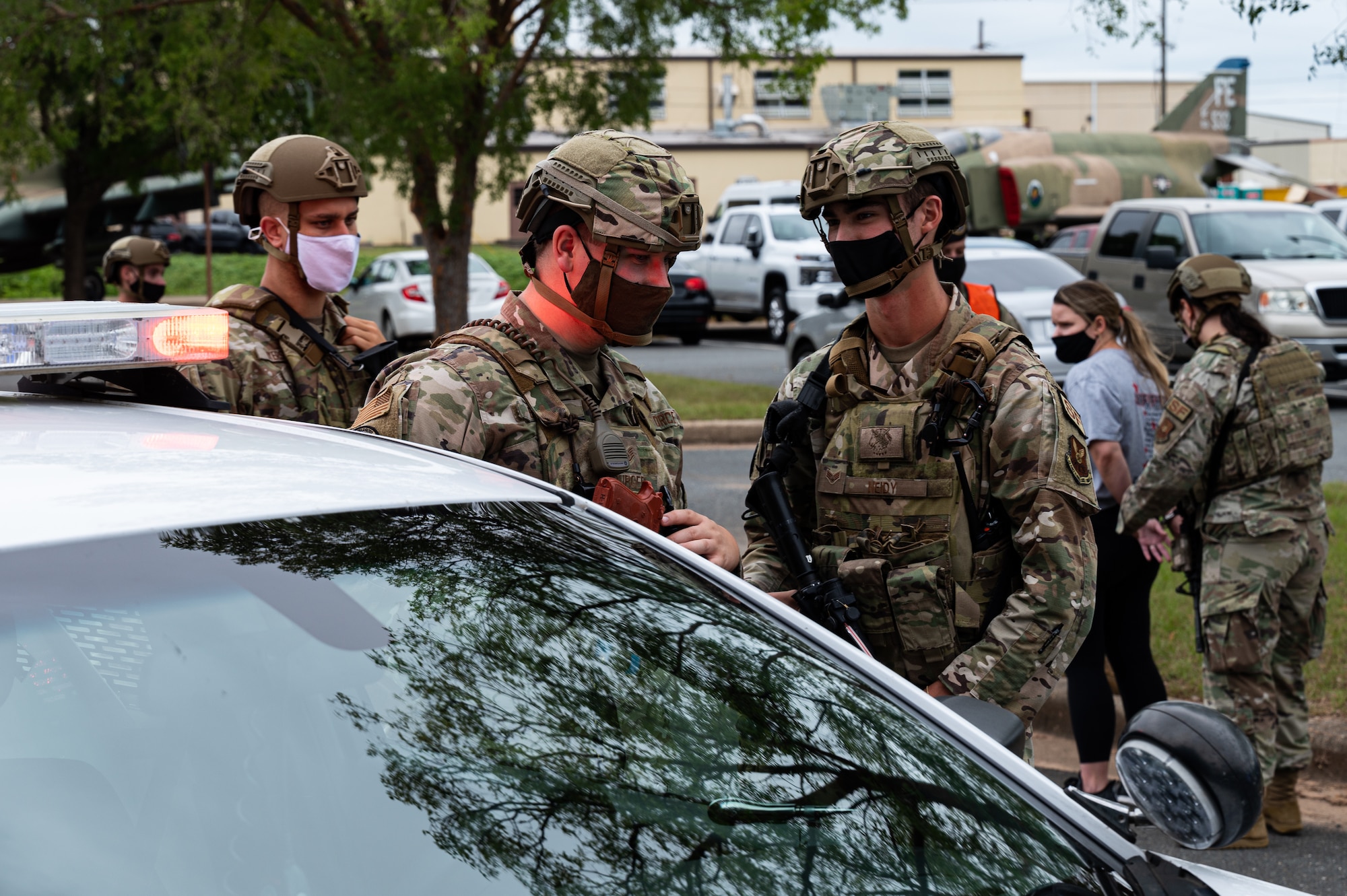 Airmen from the 2nd Security Forces Squadron regroup next to a patrol car after the extraction of a hostile actor during an active shooter exercise at Barksdale Air Force Base, Louisiana, Sept. 16, 2021. The 2nd SFS Airmen are the first to respond to an active shooter and they're tasked with neutralizing the threat and protecting base personnel. (U.S. Air Force photo by Airman 1st Class Jonathan E. Ramos)