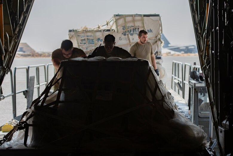 A photo of Airmen pushing a pallet