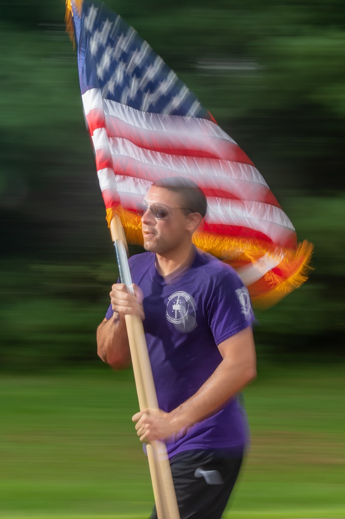 Staff Sgt. Tyler McKee, 436th Communications Squadron wing cyber planner, runs while carrying an American flag during the 2021 POW/MIA memorial run on Dover Air Force Base, Delaware, Sept. 17, 2021. Units from across Dover AFB ran in 30-minute increments for 12 hours leading to a retreat ceremony commemorating National POW/MIA Recognition Day. (U.S. Air Force photo by Mauricio Campino)
