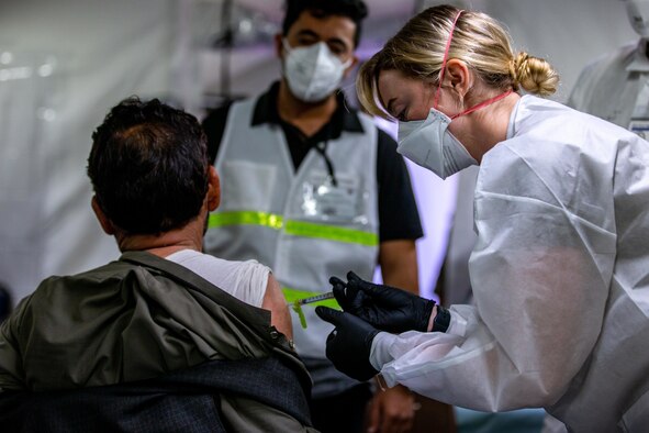 U.S. Air Force 1st Lt. Annie Darroch, a registered nurse (RN) with the 96th Medical Group, provides a Pfizer COVID vaccine to an Afghan individual on Fort Pickett, Virginia, Sept. 18, 2021.