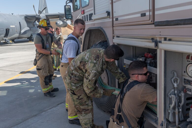 U.S. Airmen with the 332nd Expeditionary Medical Group and the 332nd Expeditionary Civil Engineering Squadron participate in a rescue exercise for a simulated aircraft fire