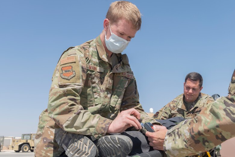 U.S. Airmen with the 332nd Expeditionary Medical Group and the 332nd Expeditionary Civil Engineering Squadron participate in a rescue exercise for a simulated aircraft fire
