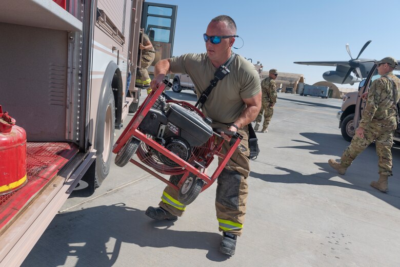 U.S. Airmen with the 332nd Expeditionary Medical Group and the 332nd Expeditionary Civil Engineering Squadron participate in a rescue exercise for a simulated aircraft fire