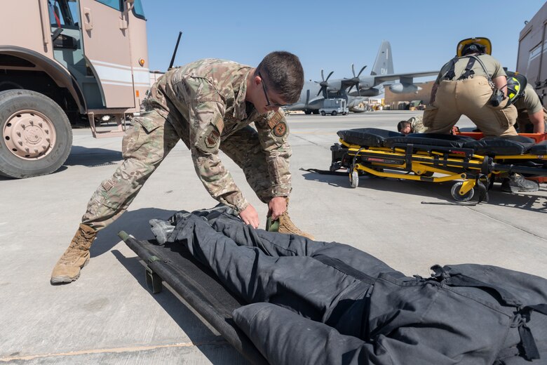 U.S. Airmen with the 332nd Expeditionary Medical Group and the 332nd Expeditionary Civil Engineering Squadron participate in a rescue exercise for a simulated aircraft fire