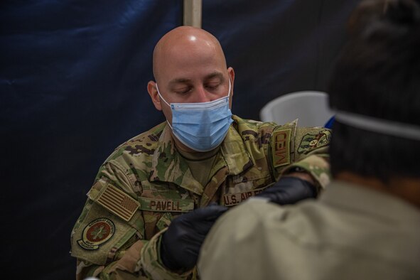An Airman attached to Task Force-Holloman administers a vaccination to an Afghan evacuee in support of Operation Allies Welcome on Holloman Air Force Base, New Mexico, Sept. 20, 2021. The Department of Defense, through U.S. Northern Command, and in support of the Department of State and Department of Homeland Security, is providing transportation, temporary housing, medical screening, and general support for at least 50,000 Afghan evacuees at suitable facilities, in permanent or temporary structures, as quickly as possible. This initiative provides Afghan evacuees essential support at secure locations outside Afghanistan. (U.S. Army photo by Pfc. Anthony Sanchez)