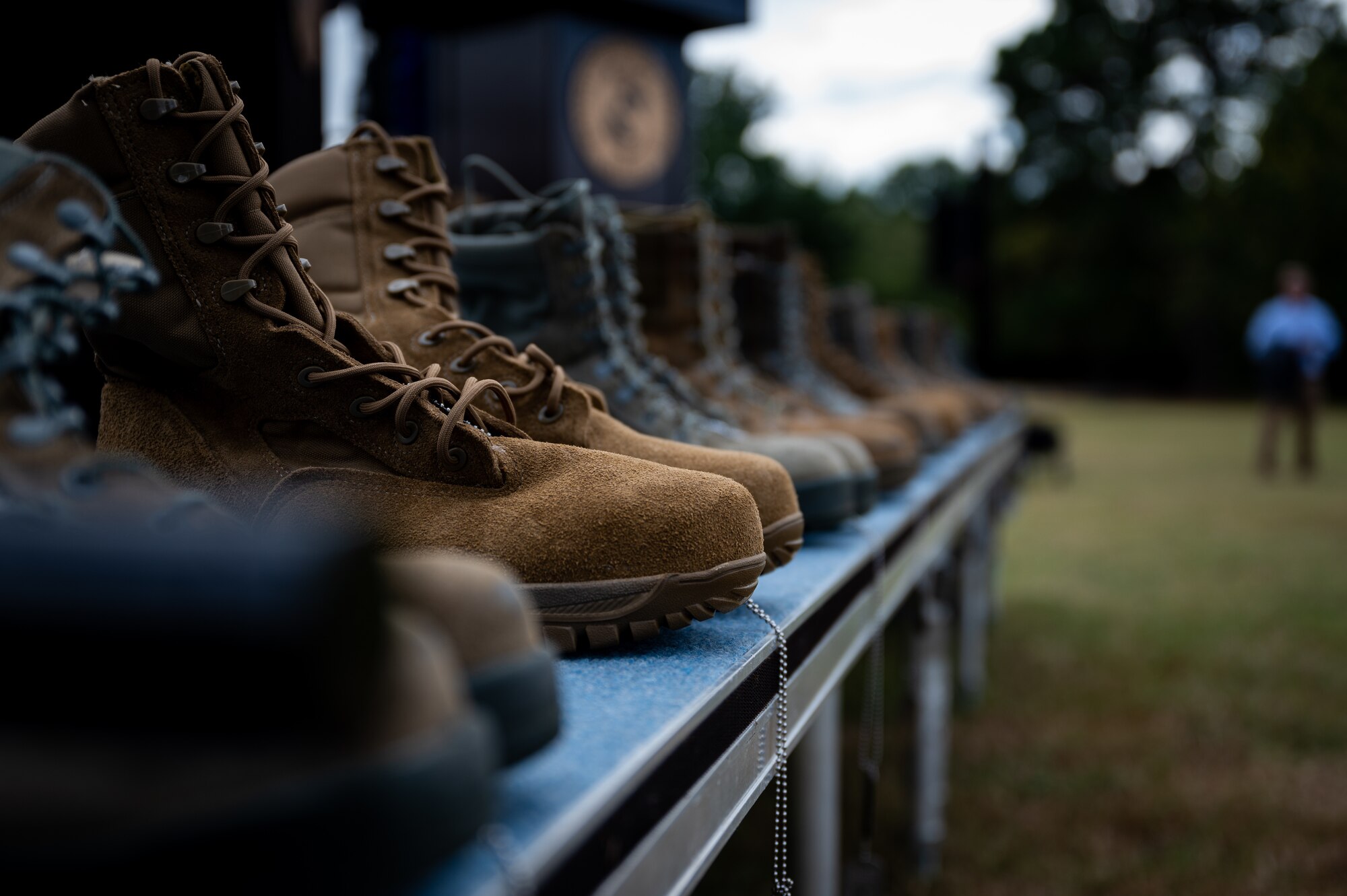 Boots are lined up on stage at a POW/MIA remembrance ceremony in Goldsboro, North Carolina, Sept. 17, 2021. The boots were placed on the stage during the closing ceremony for POW/MIA week. (U.S. Air Force photo by Senior Airman David Lynn)