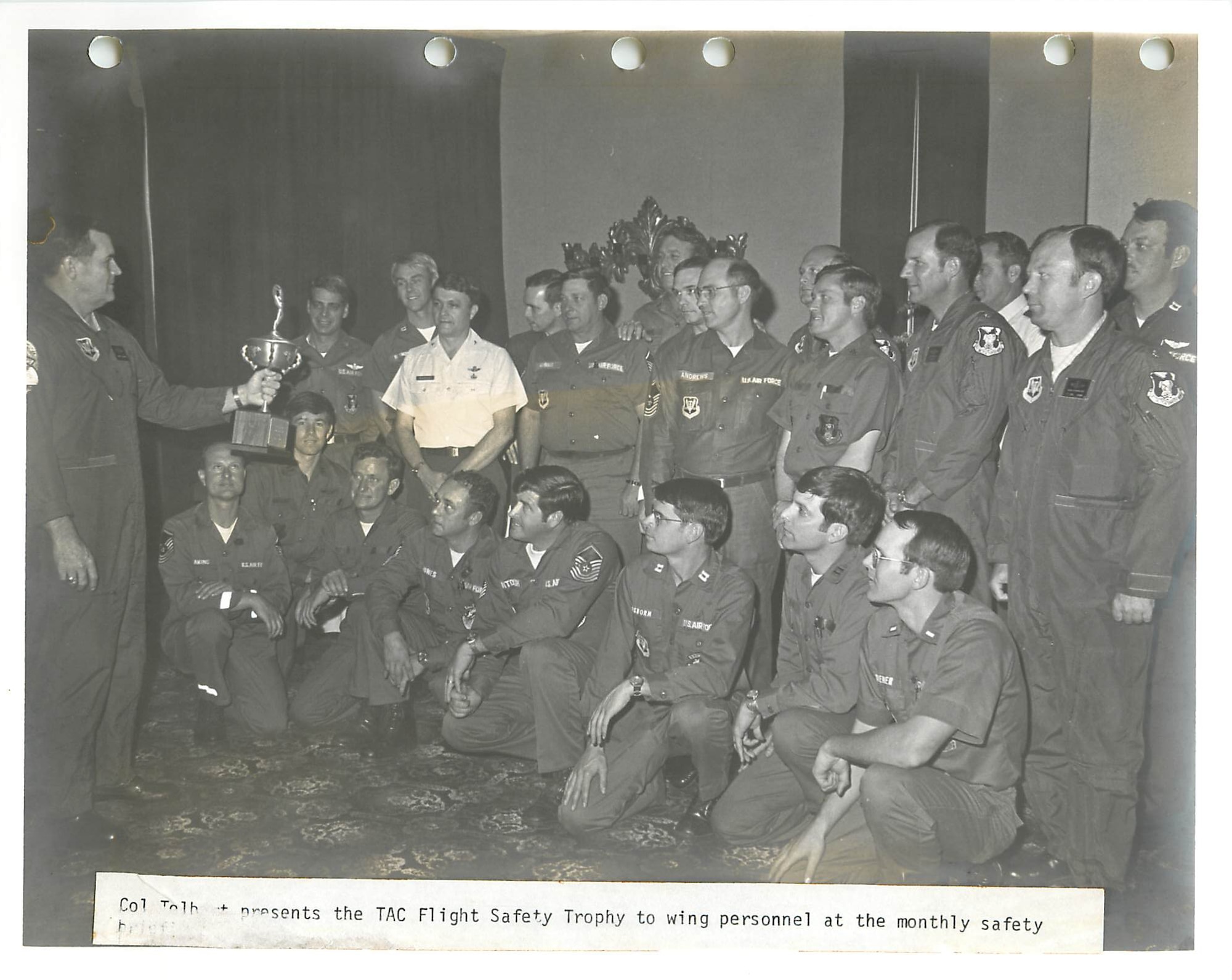 An Airman presents a trophy to a crowd of Airmen