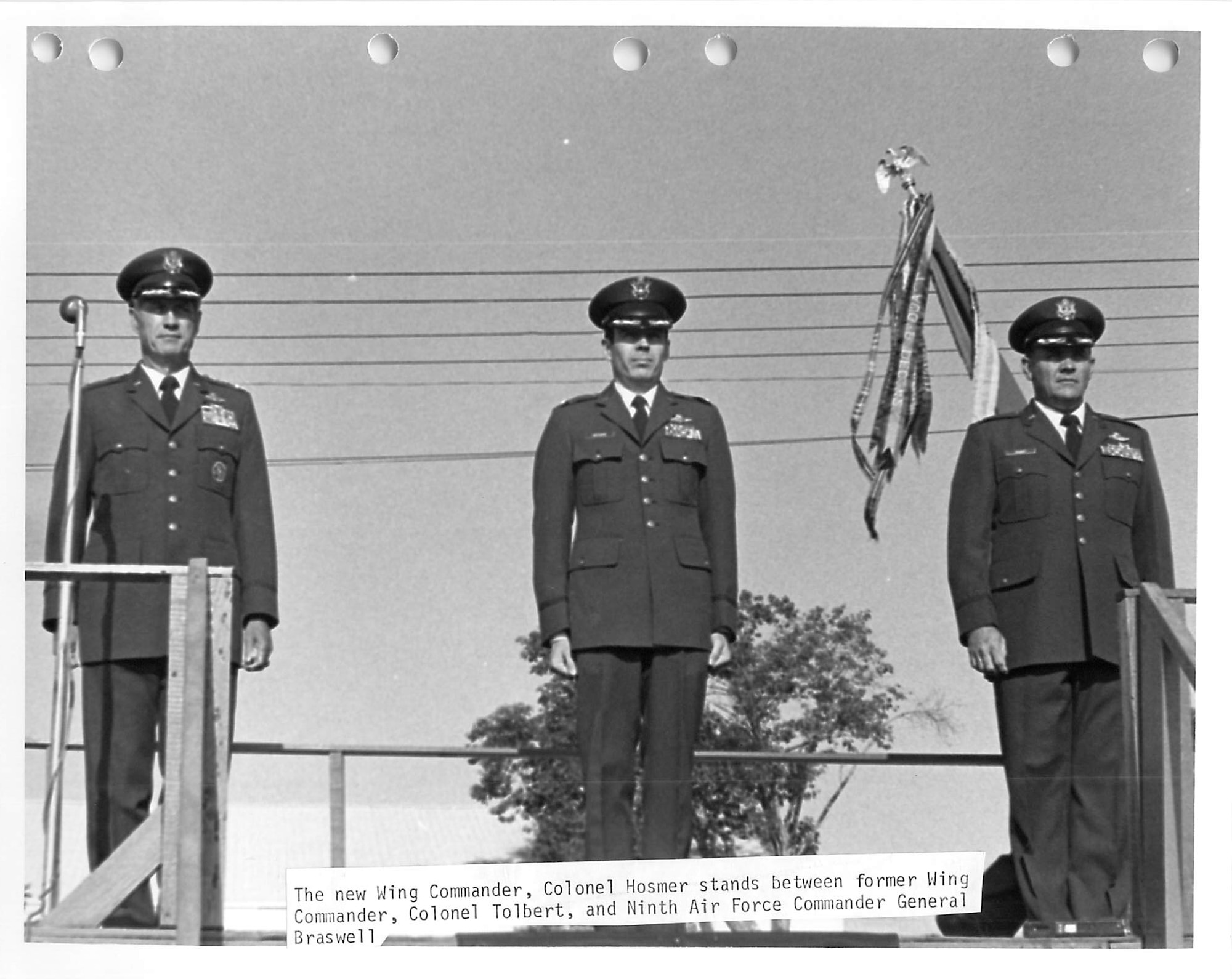 Three Airmen standing on a stage