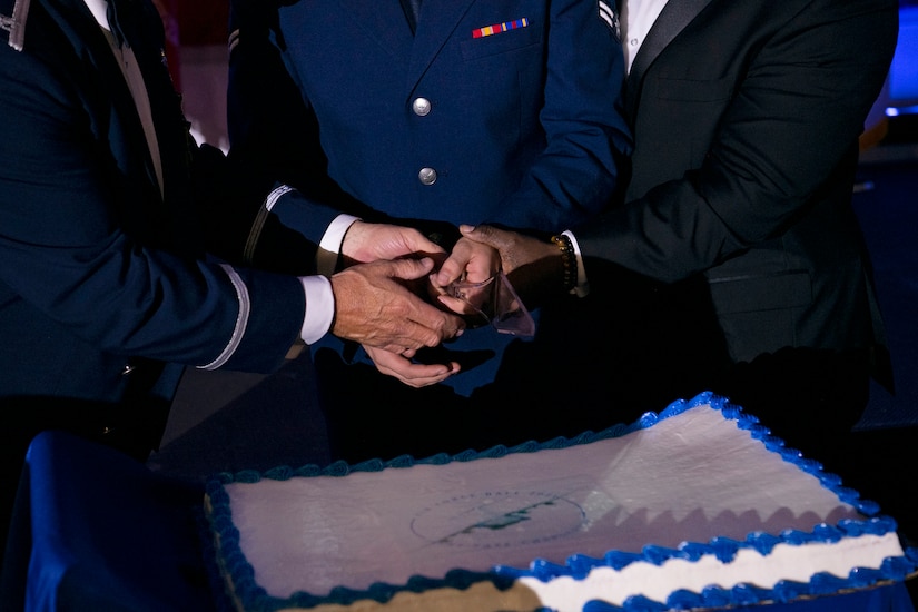 U.S. Air Force Col. Adam Willis (left), Airman 1st Class Seth Grey (middle), and retired U.S. Army Command Sgt. Maj. Patrick Alston, ceremoniously cut the cake aboard the USS YORKTOWN at Patriot’s Point, Mount Pleasant, South Carolina, Sept. 17, 2021. During the ball the youngest and oldest in attendance cut the cake together to symbolize the heritage passed between generations.