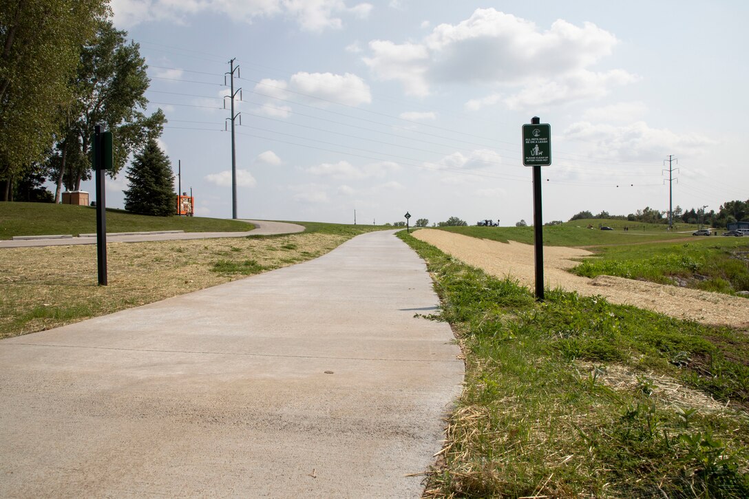 A concrete sidewalk surrounded by green grass.