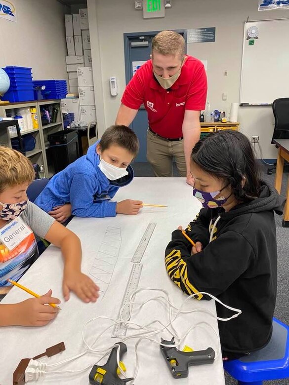 Garrison Myer offers technical and practical advice to students during the bridge building exercise following his presentation on Engineering at STARBASE Academy Winchester on Sept. 20, 2021.