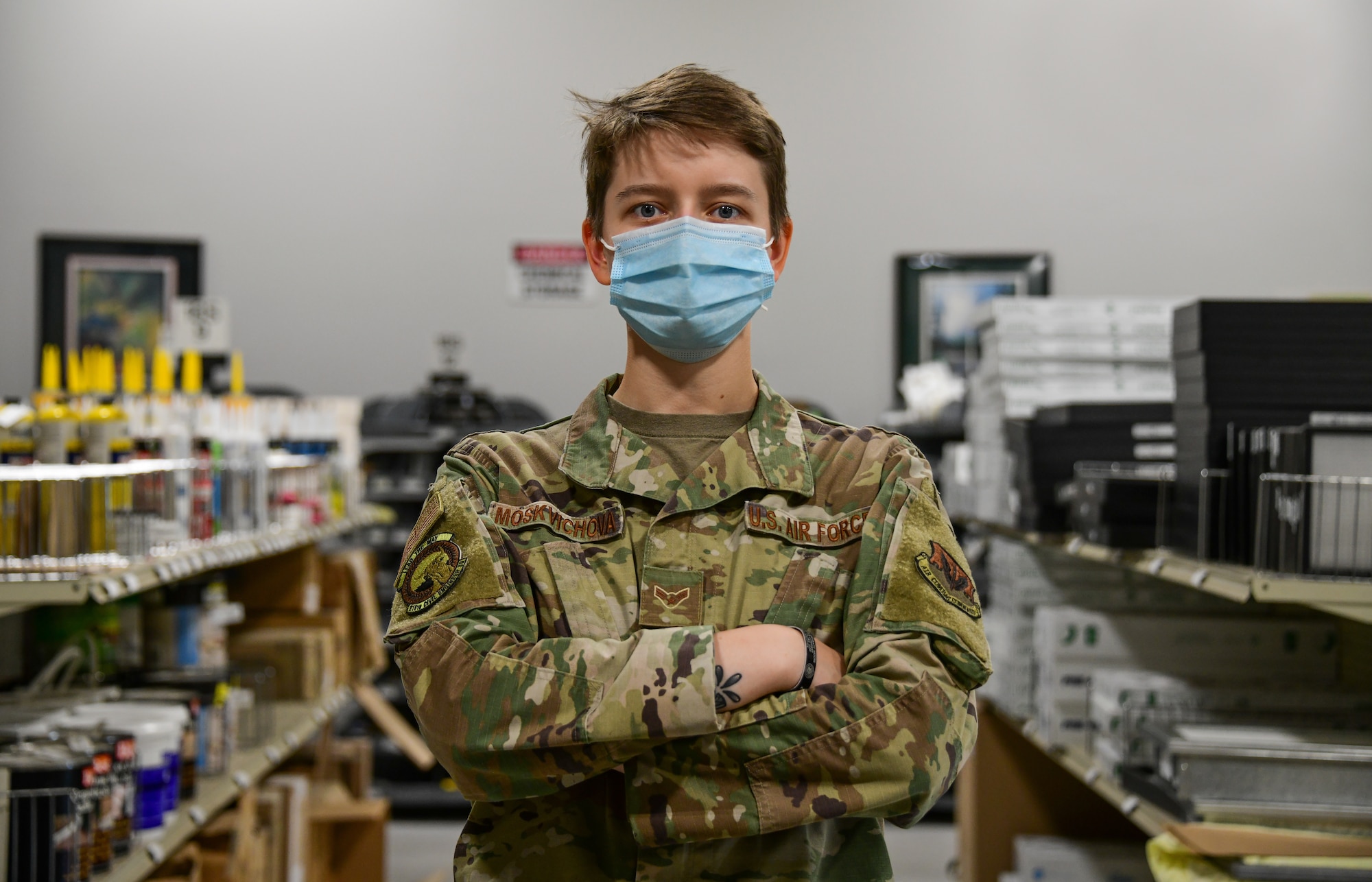 A1C Moskvichova poses for a photo in front of shelves of supplies in the material control warehouse