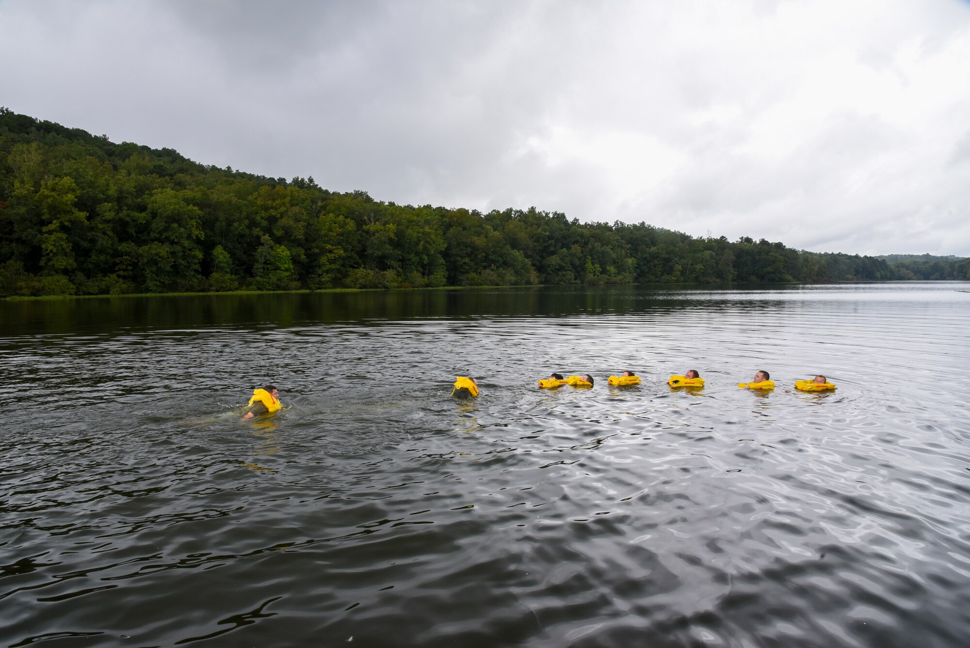 Airmen form a chain during water survival training.