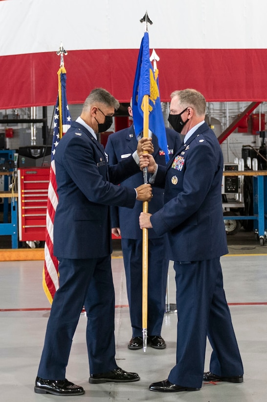 Col. Glenn Collins, 932nd Airlift Wing commander, passes the 932nd Operations Group guidon to Lt. Col. Daniel Davis, 932nd Airlift Wing, incoming Ops Group commander, during the 932nd Operations Group assumption of command ceremony, Scott Air Force Base, Illinois, Sept. 11, 2021. Davis joins the 932nd Ops Group from Tanker/Operations Support Airlift Requirements Office of the Air Force Reserve, Headquarters, where he served as the chief. (U.S. Air Force Photo by Staff Sgt. Brooke Spenner)