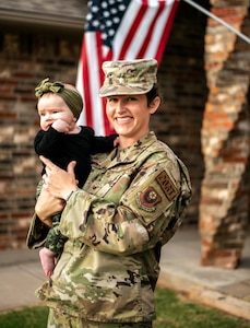 Oklahoma Air National Guard Staff Sgt. Macey Winegarner, an air transportation non-commissioned officer with the 137th Special Operations Wing, holds her six month old in Mustang, Oklahoma, Sept. 13, 2021. Winegarner donated 120oz of breast milk during Hurricane Ida to a mother in need. (Oklahoma National Guard Photo By Sgt. 1st Class Mireille Merilice-Roberts)