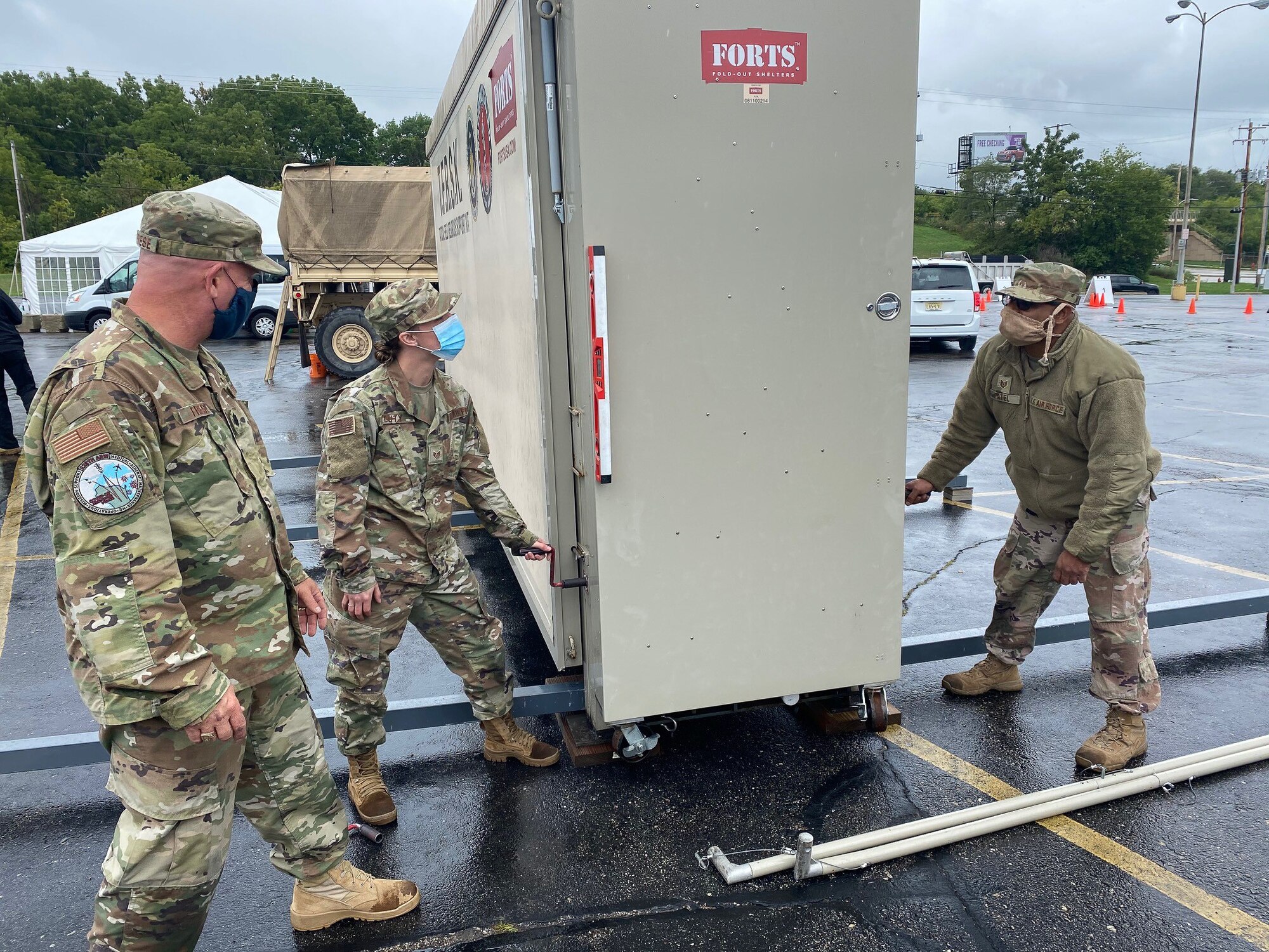 From left, Lt. Col. Friese, a 128th Air Refueling Wing chaplain, Staff Sgt. Abigail Luty, a 128th Air Refueling Wing religious affairs Airman, and Tech Sgt. Gautambhai Patel, 128th Air Refueling Wing readiness non-commissioned officer in charge, establish the tactical field religious support kit at a coronavirus specimen collection site in Milwaukee, Wis. August 2020. Nearly 700 Citizen Soldiers and Airmen from the Wisconsin National Guard are currently serving in direct support of the state’s on-going response to COVID-19 in a variety of statuses. (Courtesy photo)