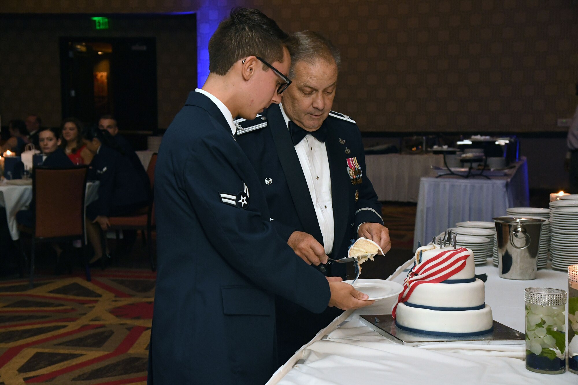 U.S. Air Force Retired Col. Randy Newcome and Airman 1st Class Josh Lentz, 81st Training Support Squadron command support staff, participate in a cake cutting ceremony during the Keesler Air Force Ball inside the Golden Nugget Casino, Biloxi, Mississippi, Sept. 18, 2021. The event, which celebrated the Air Force’s 74th birthday, also included a POW/MIA table ceremony. (U.S. Air Force photo by Kemberly Groue)