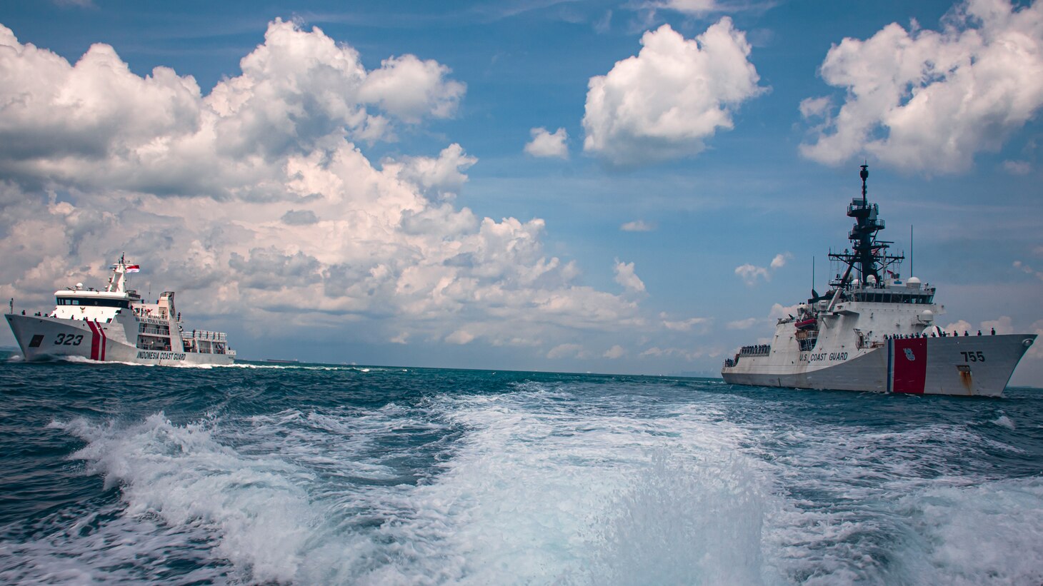 Members onboard U.S. Coast Guard Cutter Munro man the rails during a maritime engagement with the Indonesia Coast Guard in the Singapore Straight, Sept. 20, 2021. Coast Guard Cutter Munro is currently deployed to the Western Pacific to strengthen alliances and partnerships, and improve maritime governance and security in the region. (U.S. Coast Guard photo by Marine Corps Sgt. Kevin G. Rivas)