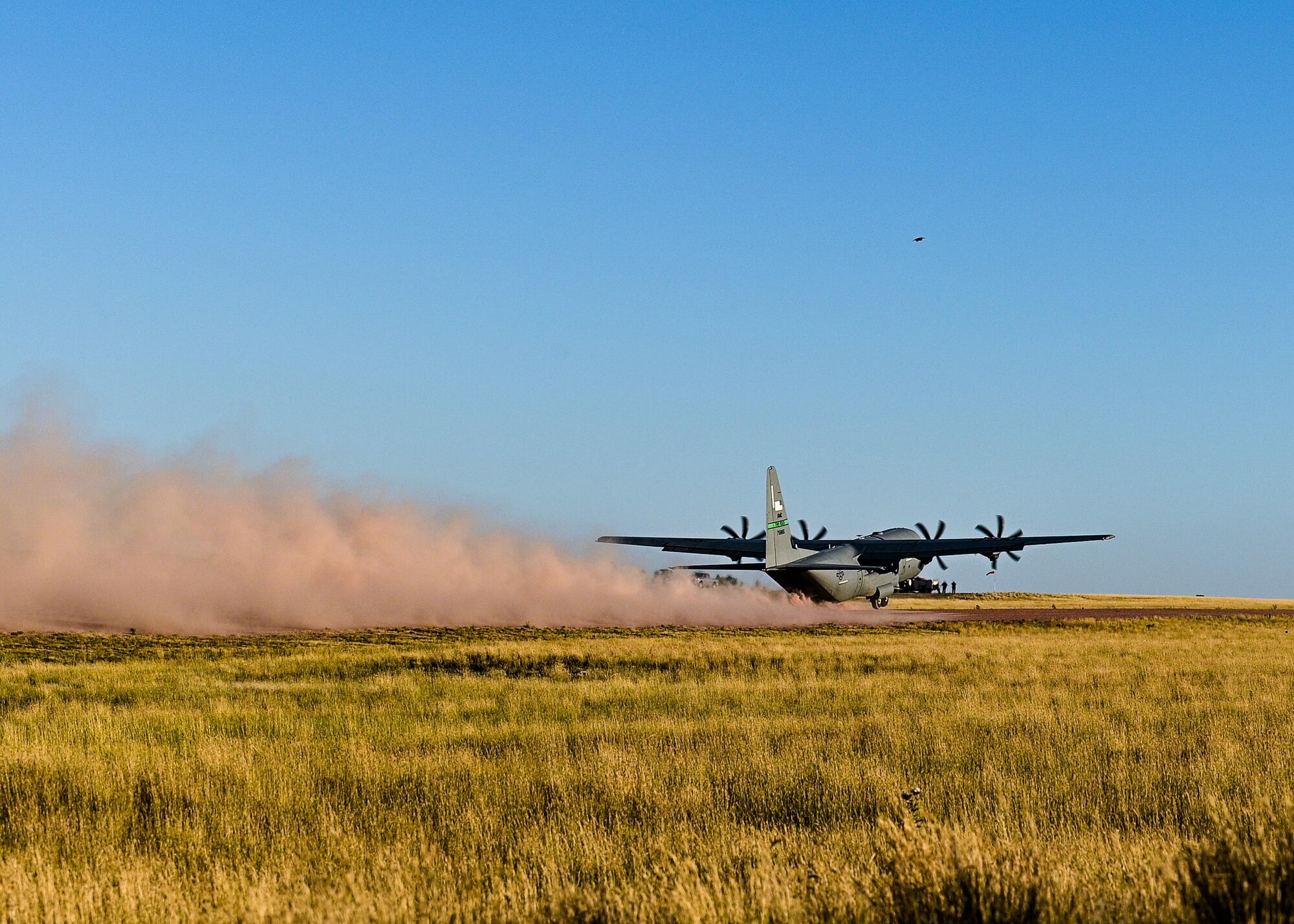 a cargo aircraft taking off from a dirt field