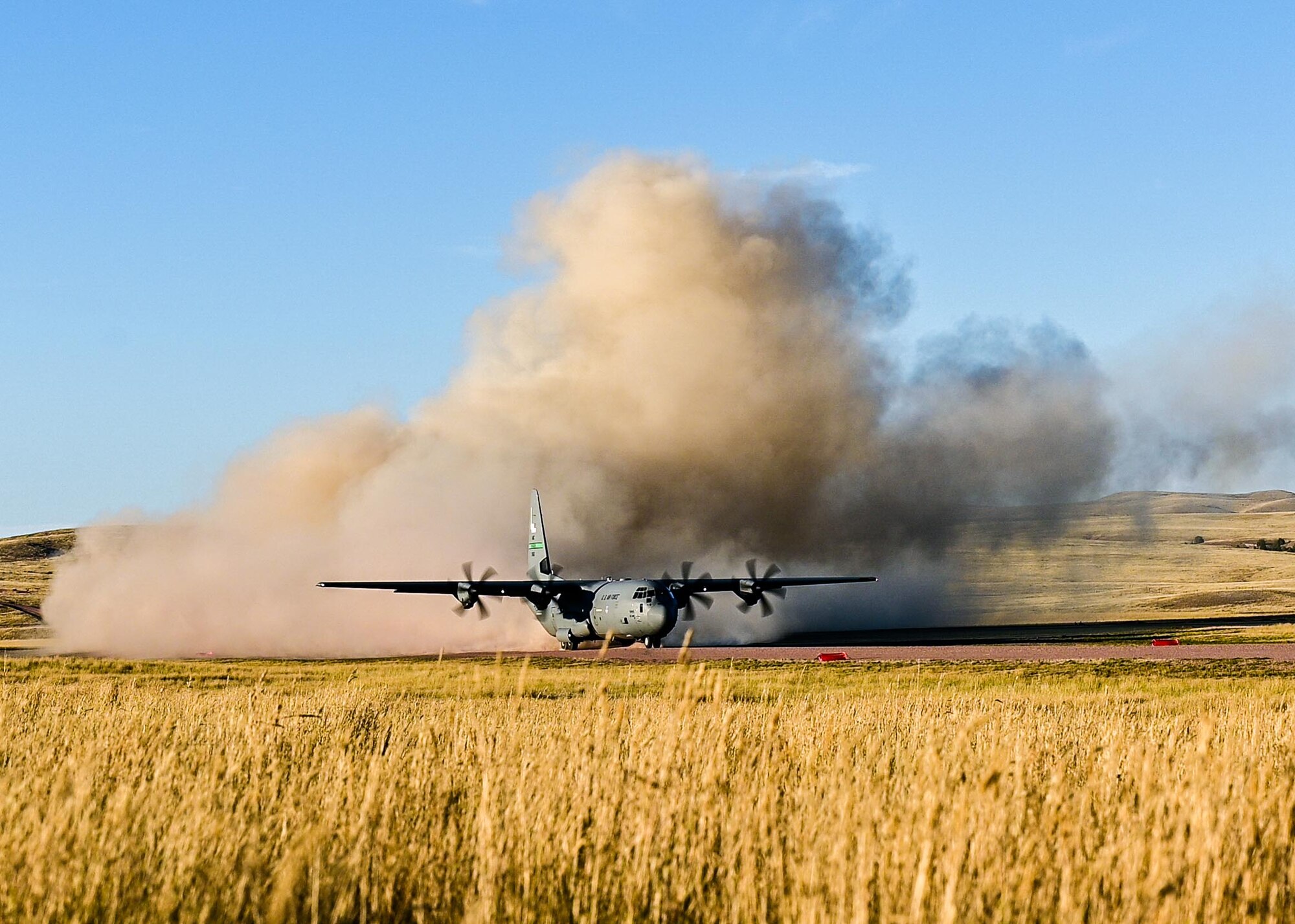 a cargo aircraft taking off from a dirt field