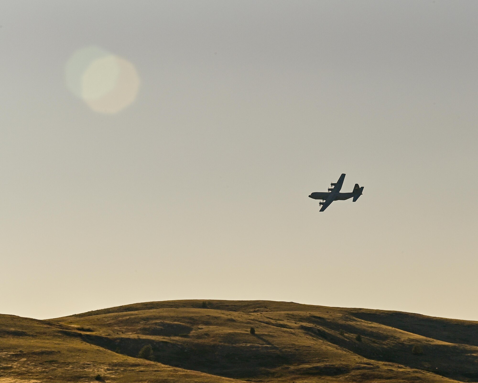 a cargo aircraft taking off from a dirt field