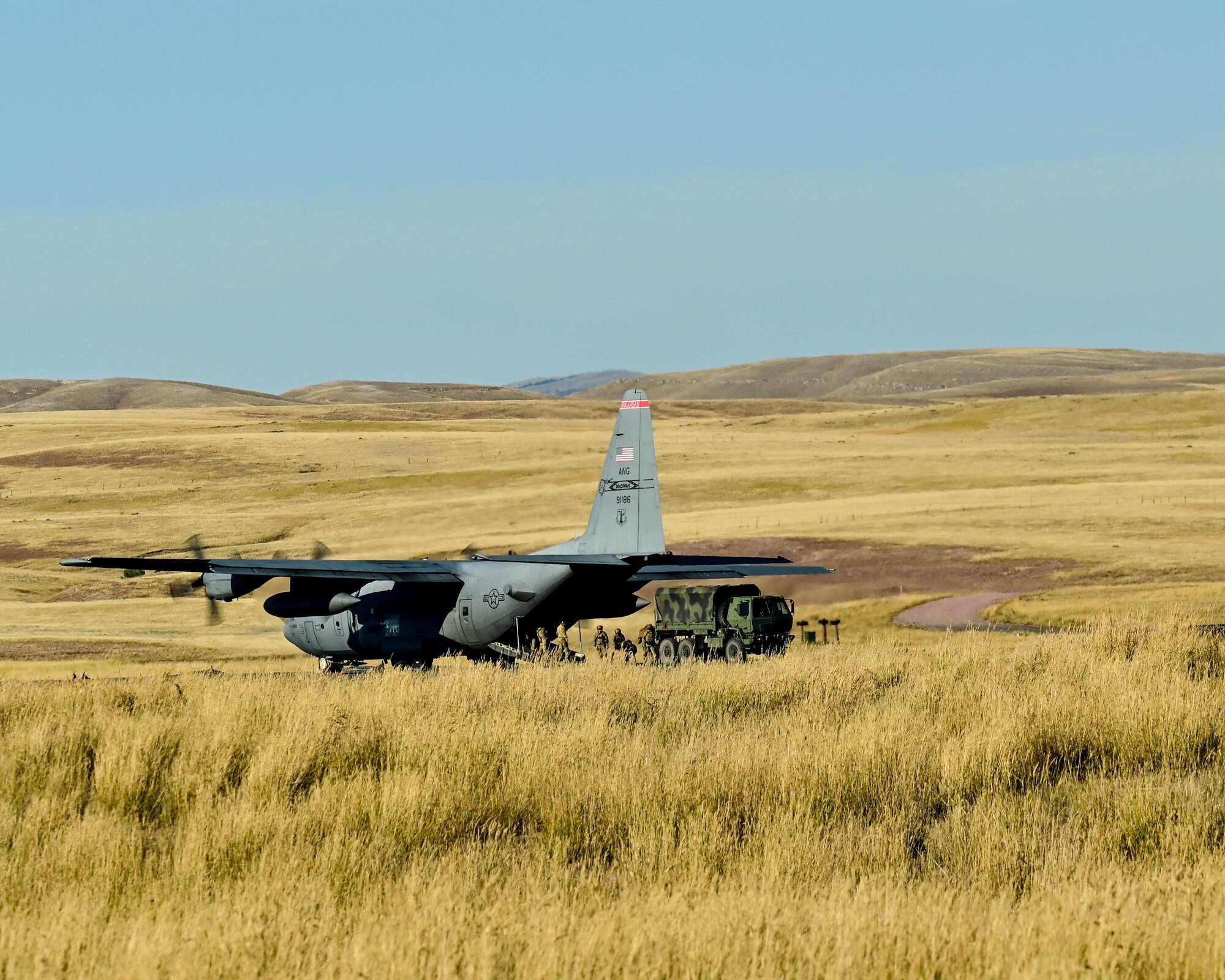a cargo aircraft taking off from a dirt field