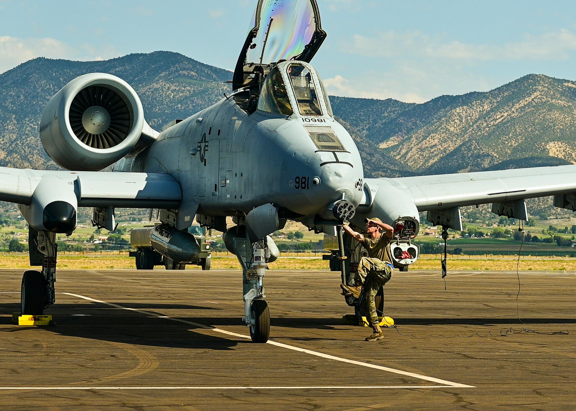 fighter aircraft parked with mountains in background