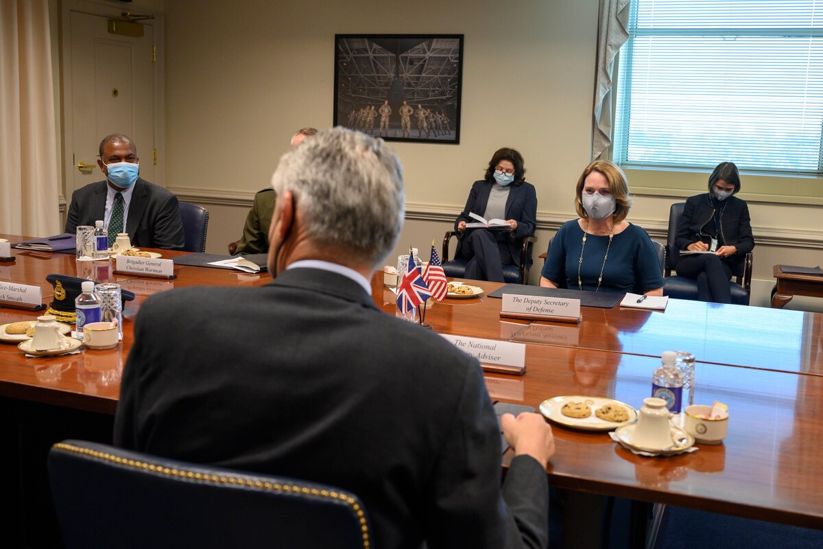 Men and women are seated at a conference table.