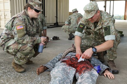 Cpl. Vaclovas Stankevičius, an infantryman with 508th Company, 5th KASP (Lithuanian Home Guard) district, Lithuanian Land Forces, treats a wound on a simulated casualty with assistance from Staff Sgt. Sparrow Kelly, an Army combat medic and instructor with Medical Battalion Training Site, Sept. 10 at Fort Indiantown Gap, Pa. Thirty-three Soldiers from Lithuania’s land forces reserve component came to Fort Indiantown Gap Sept. 6-17 for an annual platoon exchange, part of the Pennsylvania National Guard’s State Partnership Program.