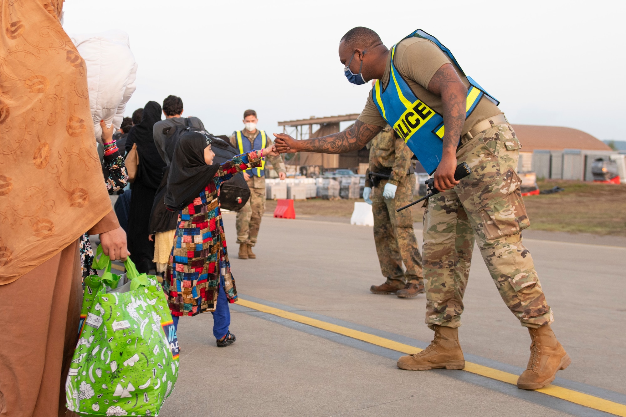 U.S. Air Force Tech. Sgt. Raymond Duesbury, right, 423rd Security Forces Squadron antiterrorism officer assigned to Royal Air Force Alconbury, England, greets a child during Operation Allies Refuge at Ramstein Air Base, Germany, Aug. 31, 2021. Operation Allies Refuge is providing support to evacuees from Afghanistan in the form of food, medical services, and temporary lodging while they await transportation to other transient locations. Ramstein Air Base transformed into U.S. European Command’s primary evacuation hub, supporting one of the largest, most complex humanitarian airlift operations in history. (U.S. Air Force photo by Senior Airman Jennifer Zima)