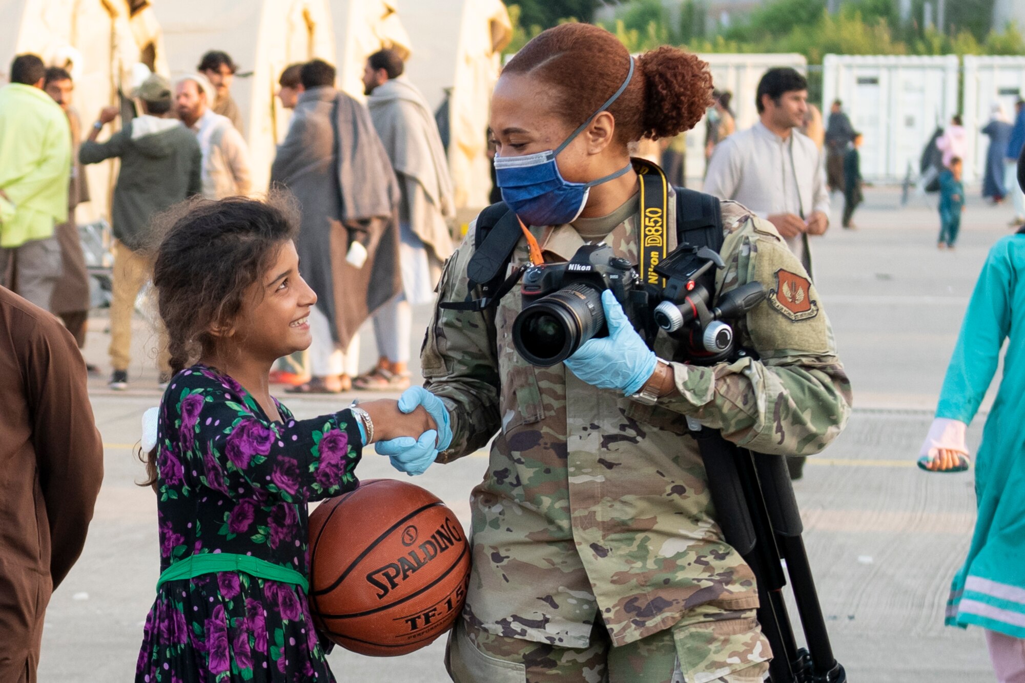 U.S. Air Force Senior Airman Gabrielle Winn, 501st Combat Support Wing public affairs journeyman, greets a child during Operation Allies Refuge at Ramstein Air Base, Germany, Aug. 31, 2021. Volunteers work around the clock to support evacuees during their time at Ramstein. Ramstein Air Base transformed into U.S. European Command’s primary evacuation hub, supporting one of the largest, most complex humanitarian airlift operations in history. (U.S. Air Force photo by Senior Airman Jennifer Zima)