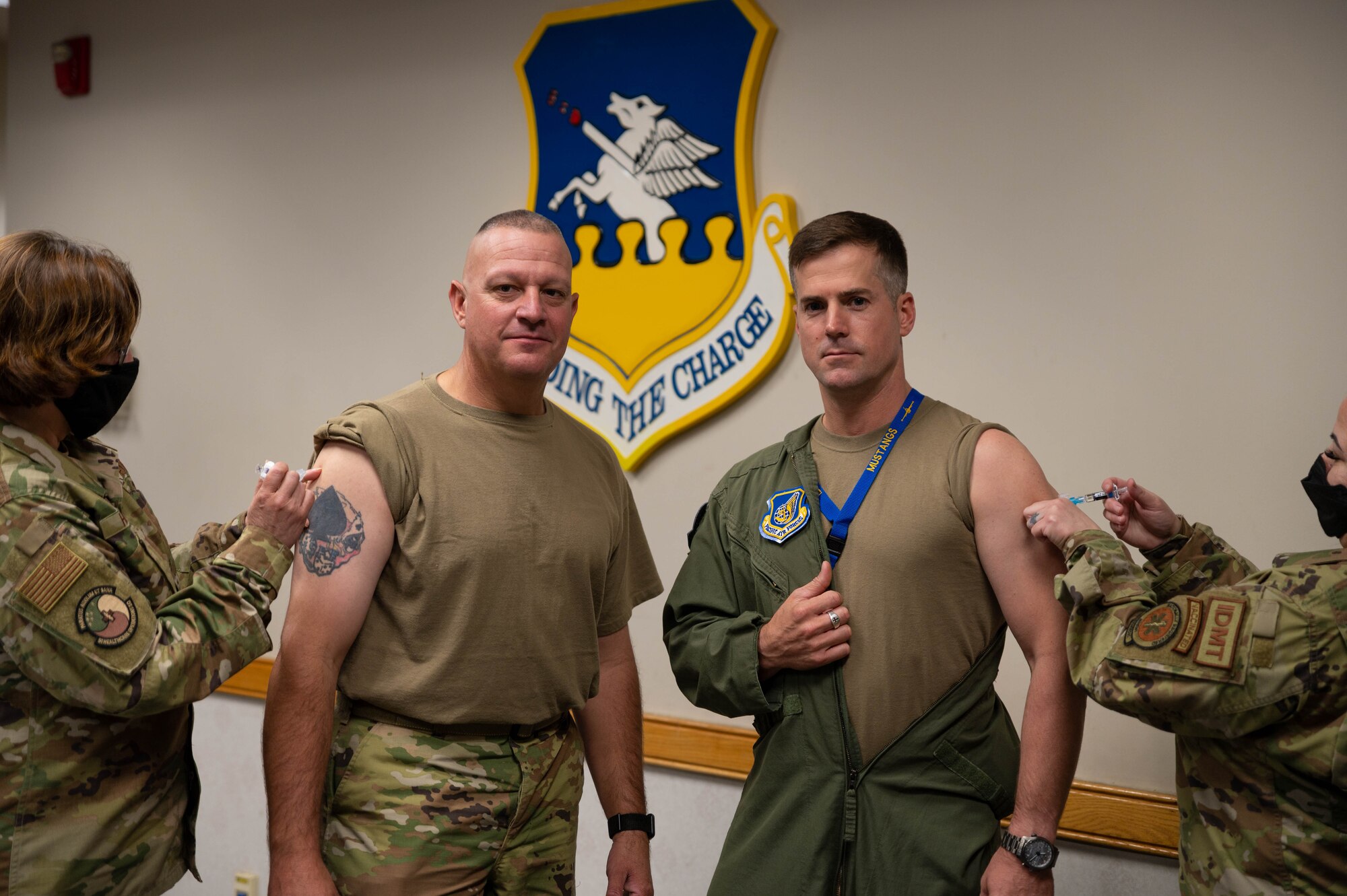 Chief Master Sgt. Justin Apticar, 51st Fighter Wing command chief (left), and Col. Joshua Wood, 51st Fighter Wing commander, receive their flu shots
