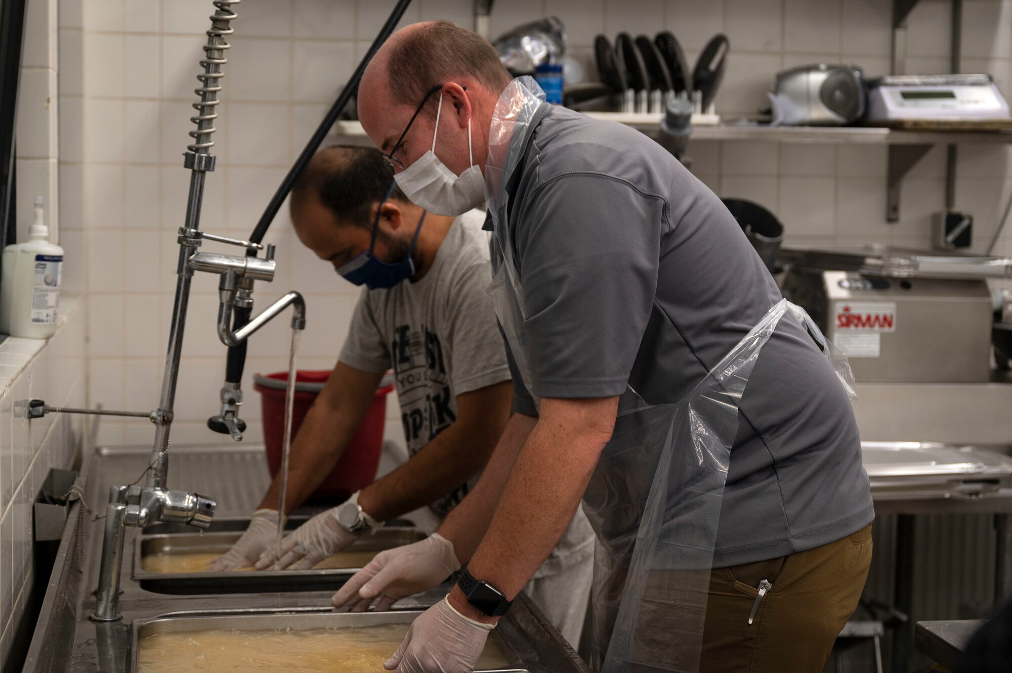 Evacuee chefs clean rice.