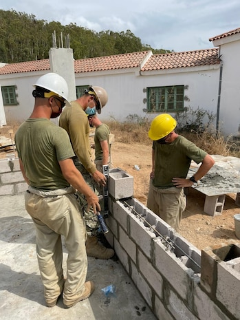 The joint, combined engineer team methodically lay concrete masonry blocks for the walls of the new seven meter by eighteen meter concrete medical building at the Tabarka regional Hospital.