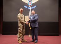 Incoming Product Manager Air Warrior (PdM AW), Dr. Carlos Correia, receives the Product Manager Air Warrior Charter from Col. Derek Bird, Project Manager Soldier Survivability, during a Change of Charter ceremony held on Redstone Arsenal, Alabama, July 16. PdM AW is a product management office within the Program Executive Office (PEO) Soldier portfolio.