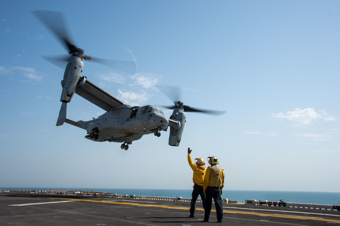 ARABIAN GULF (September 19, 2021) Aviation Boatswain’s Mate (Handling) 3rd Class Chad Kihoi signals to an MV-22B Osprey attached to Marine Medium Tilt-Rotor Squadron (VMM) 165 (Reinforced), 11th Marine Expeditionary Unit (MEU), aboard the amphibious assault ship USS Essex, Sept. 19. Essex and the 11th Marine Expeditionary Unit are deployed to the U.S. 5th Fleet area of operations in support of naval operations to ensure maritime stability and security in the Central Region, connecting the Mediterranean and the Pacific through the western Indian Ocean and three strategic choke points. (U.S. Navy photo by Mass Communication Specialist 3rd Class Isaak Martinez)