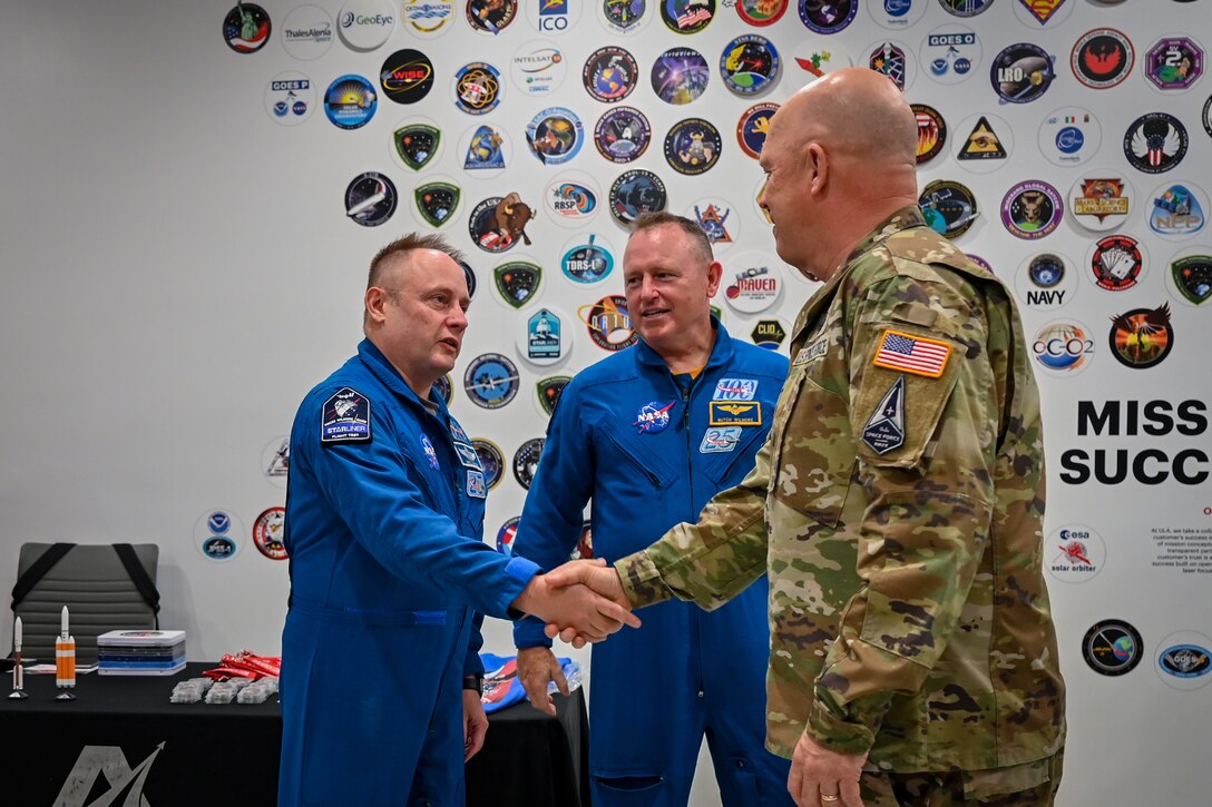 General shakes hand with astronaut.