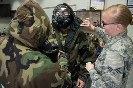 U.S. Air Force Senior Airman Tara Neitzel, a CBRNE (Chemical, Biological, Radiological, Nuclear, and Explosives) instructor from the 146th Airlift Wing’s Civil Engineer Squadron, assists California Air National Guard Tech. Sgt. Juan Ramos and Staff Sgt. Jason McCauley, as they practice donning MOPP (Mission Oriented Protective Posture) gear at the Channel Islands Air National Guard Station, Port Hueneme, California, February 8, 2020.