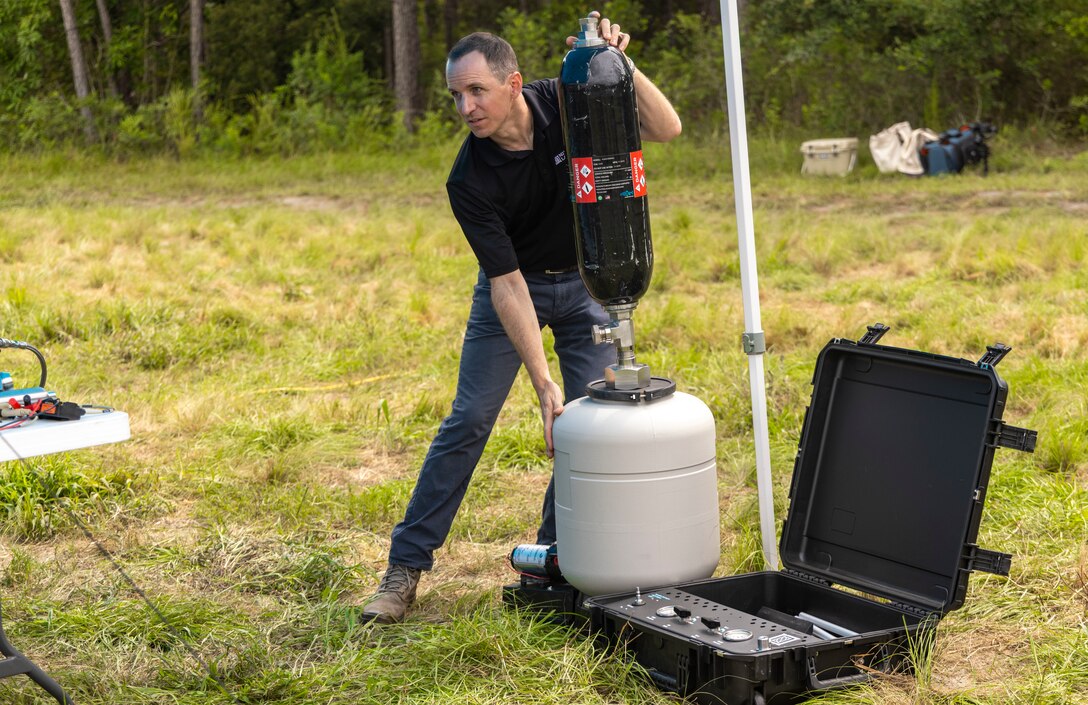 A representative of Massachusetts Institute of Technology Lincoln Labs gathers equipment for a demonstration of the capabilities of the Hydrogen- Tactical Refueling Point on Camp Lejeune, N.C., Sept. 16, 2021. The H-TaRP is intended to be used to power unmanned aerial vehicles and meets clean energy demands of the future without downgrading performance. (U.S. Marine Corps photo by Lance Cpl. Cheyenne Stillion)