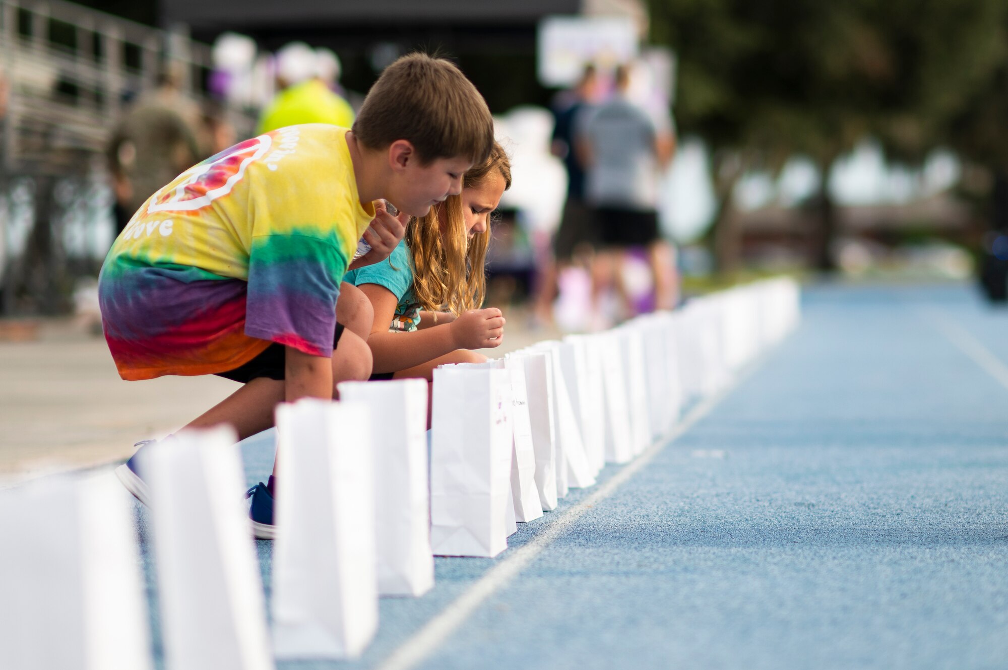 Photo of kids placing lights into paper bags