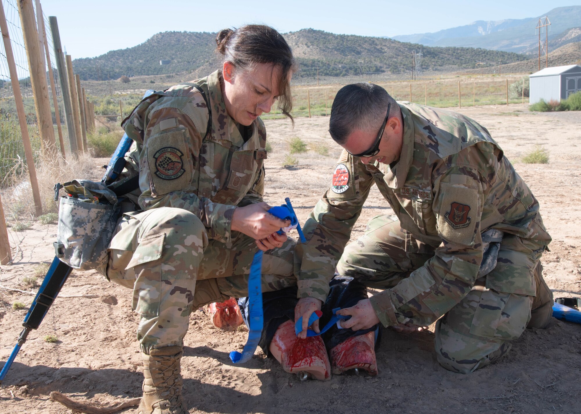 two airmen provide medical assistance to a dummy