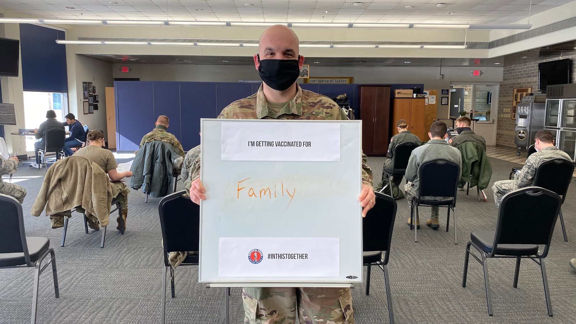 A member of the 128th Air Refueling Wing holds up a sign signifying why they are choosing to receive the COVID-19 Vaccine here at 128th Air Refueling Wing, Milwaukee, Feb. 7, 2020. The 128th Air Refueling Wing has begun the distribution of the COVID-19 vaccine in coordination with the U.S. Department of Defense's Operation Warp Speed. (U.S. Air National Guard photo by Master Sgt. Kellen Kroening)