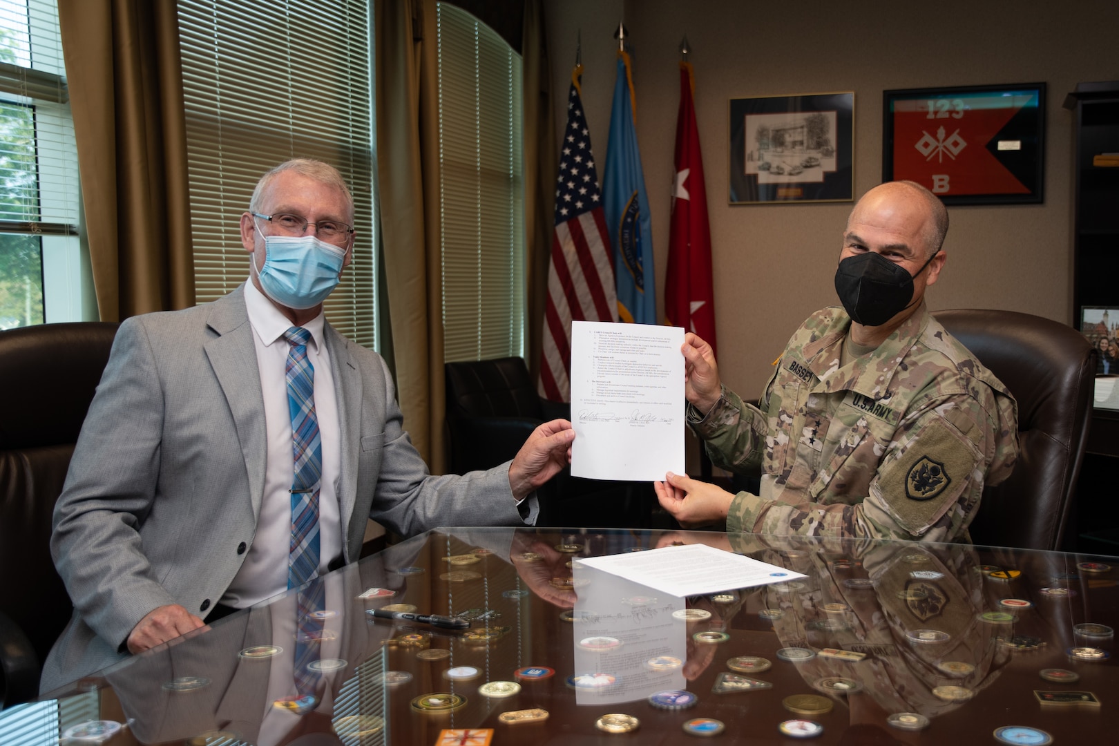 Two men holding a document between them.