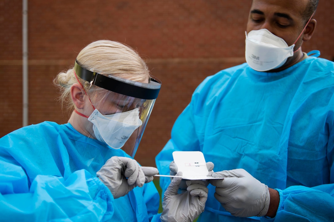 Two service members test for a virus.